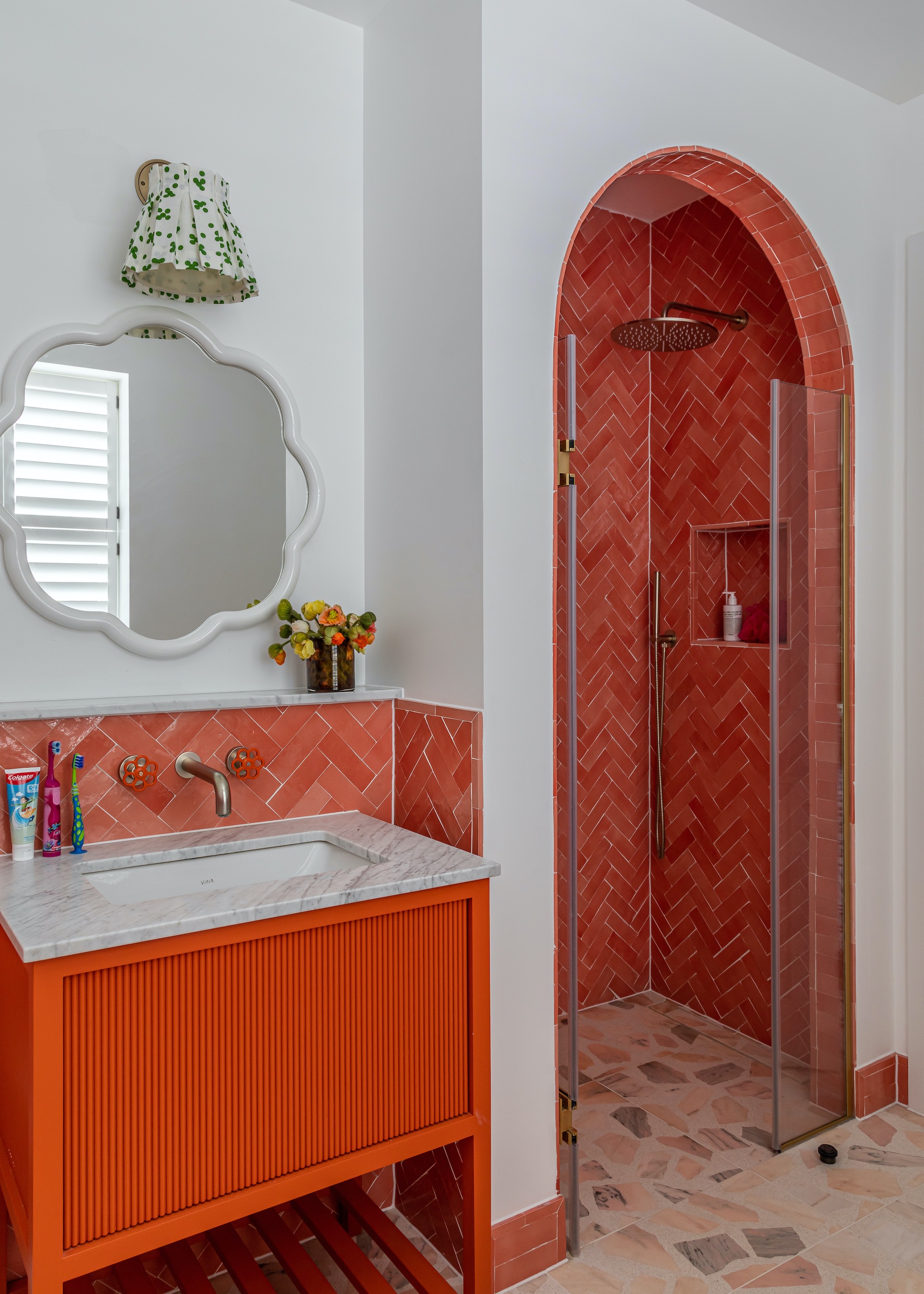 bathroom with orange zellige tiles in arched shower areas