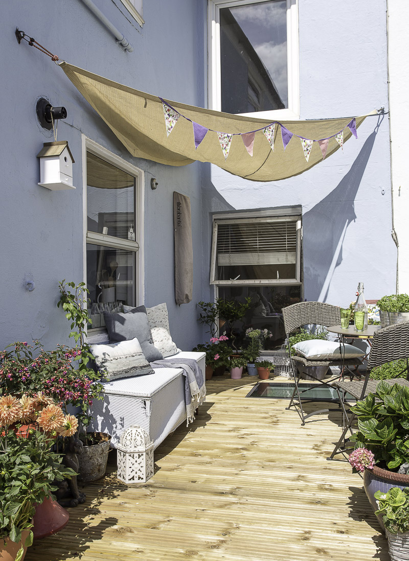 Courtyard decking area with blue walls behind a terrace