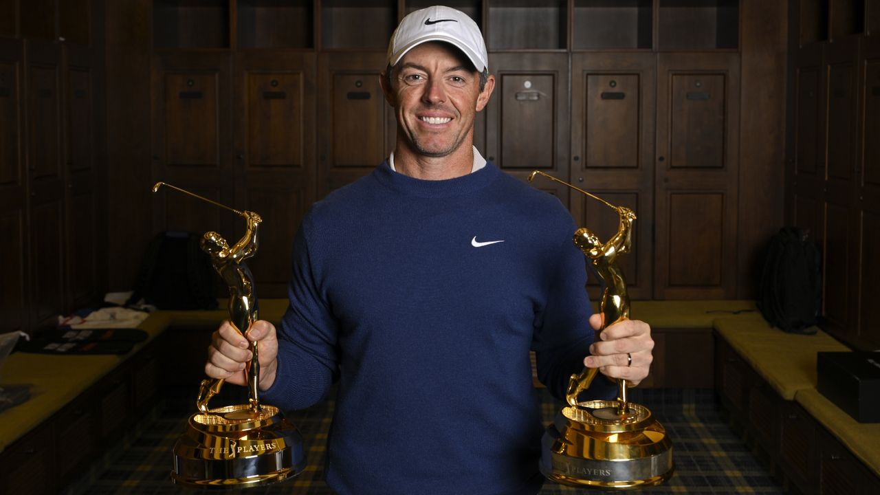 Photo of Rory McIlroy holding his two players championship trophies