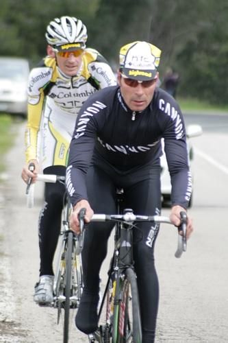 Erik Zabel and Rolf Aldag ride along behind the peloton.