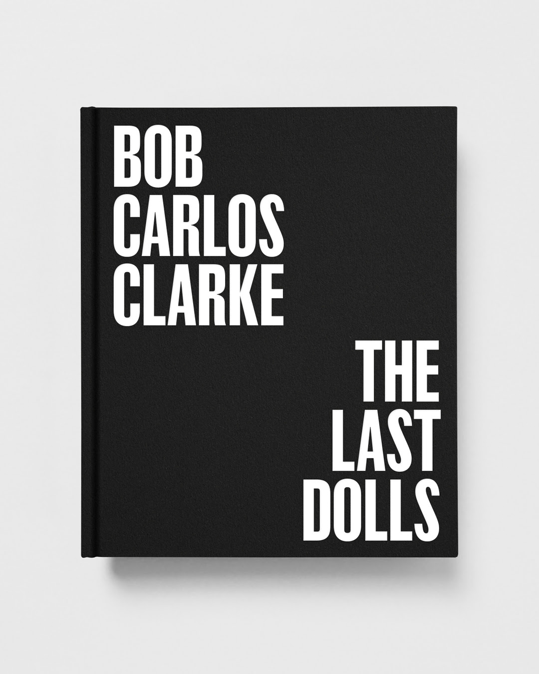 The black hardback cover of "Bob Carlos Clarke: The Last Dolls," with the title set in bold white type against a plain black background.