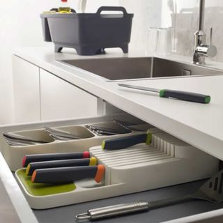 grey plastic knife block in an organised kitchen drawer