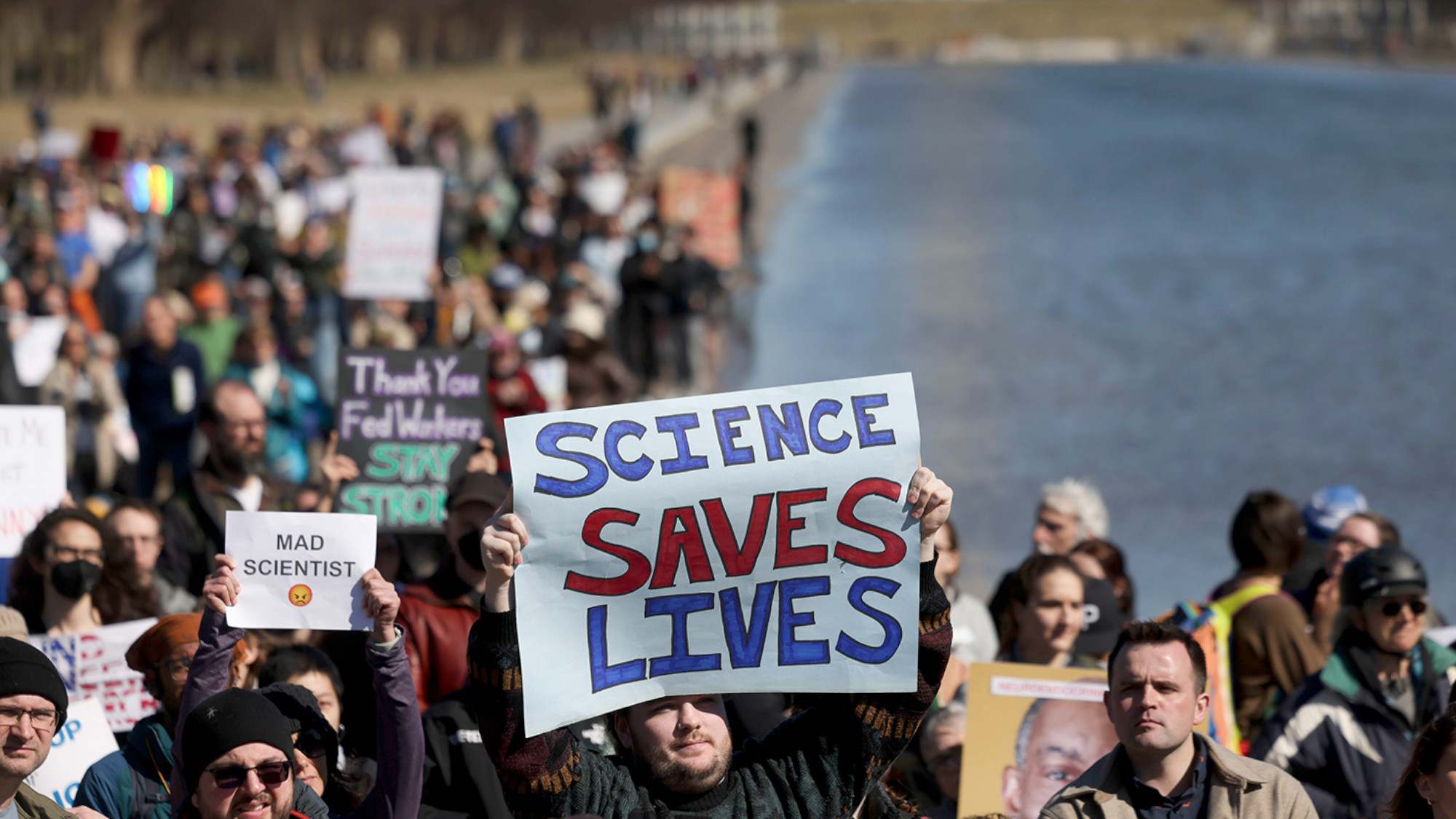 A person holds up a sign that reads 'Science Saves Lives' during a protest