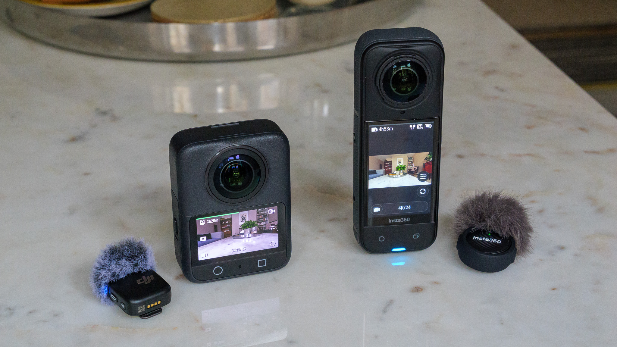 DJI Osmo 360 and Insta360 X5 on marble table with wireless microphones