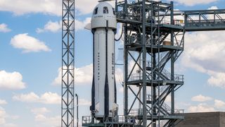 Blue Origin's New Shepard rocket surrounded by its gantry