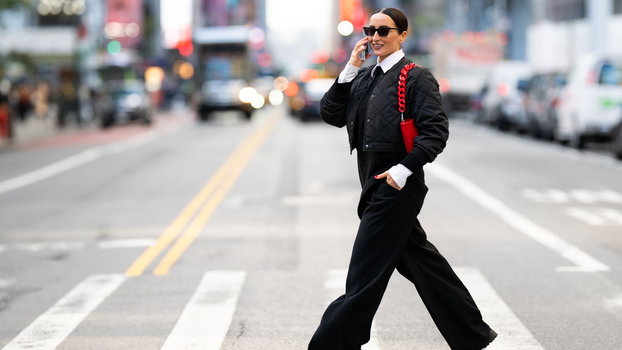 Well-dressed businesswoman walking on the street of Manhattan, New York and talking on the phone while heading to work during one autumn day.