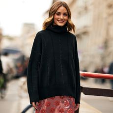 oliva palermo smiles and wears black turtleneck sweater