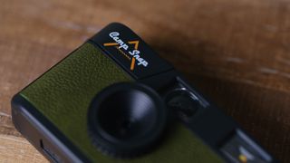 The Camp Snap camera, in forest green, sits on a table