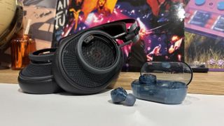 Sony wireless earbuds and Austrian Audio over-ear headphones on a desk