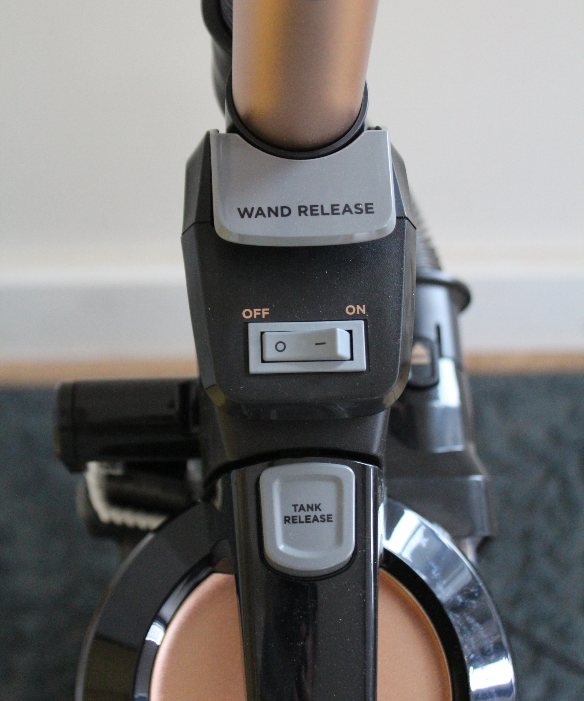 Close-up of the power, wand release and tank release buttons at the top of the Bissell SurfaceSense Allergen Pet Lift-Off Upright Vacuum