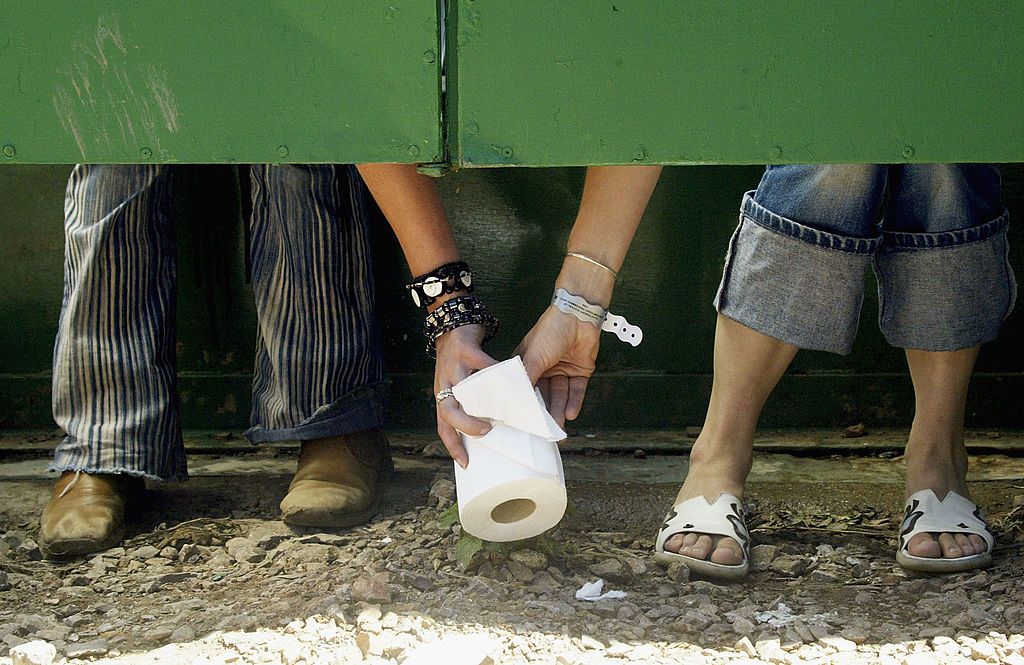 People pass a roll of toilet paper.