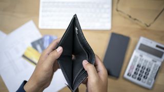 Someone opens an empty wallet over a desk
