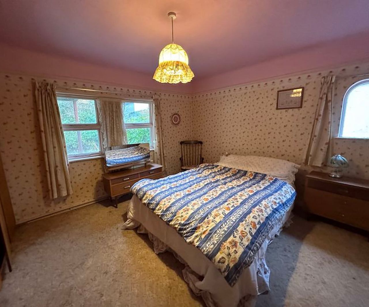 An old fashioned bedroom with wearing curtains and beige carpet