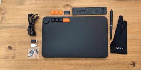 A black Veikk Voila L Pen Tablet sitting on a wooden desk