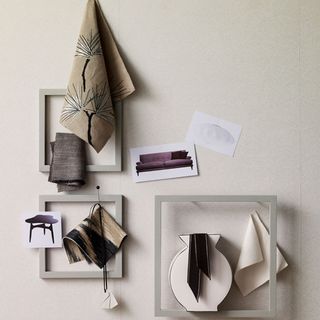 white wall with frames and hanging cloth