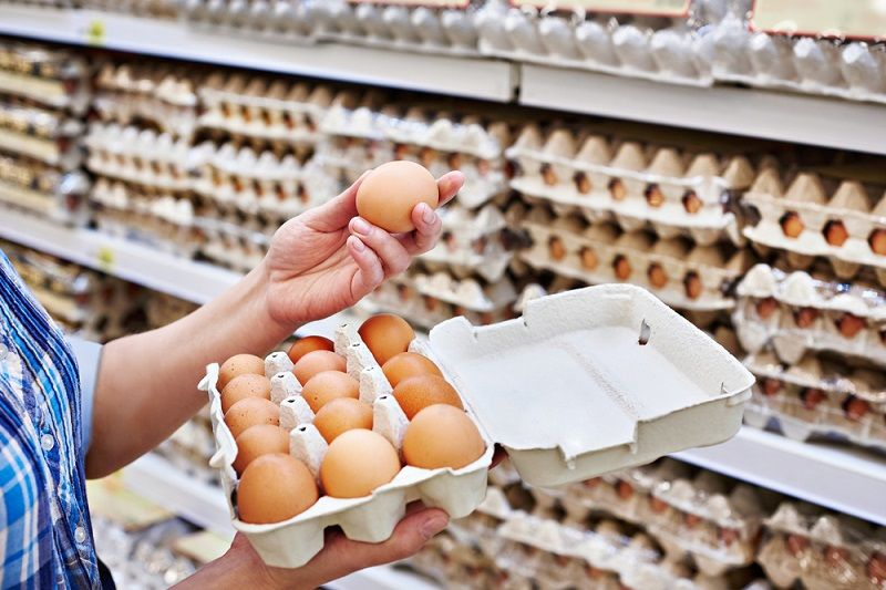 A person checking eggs in the supermarket