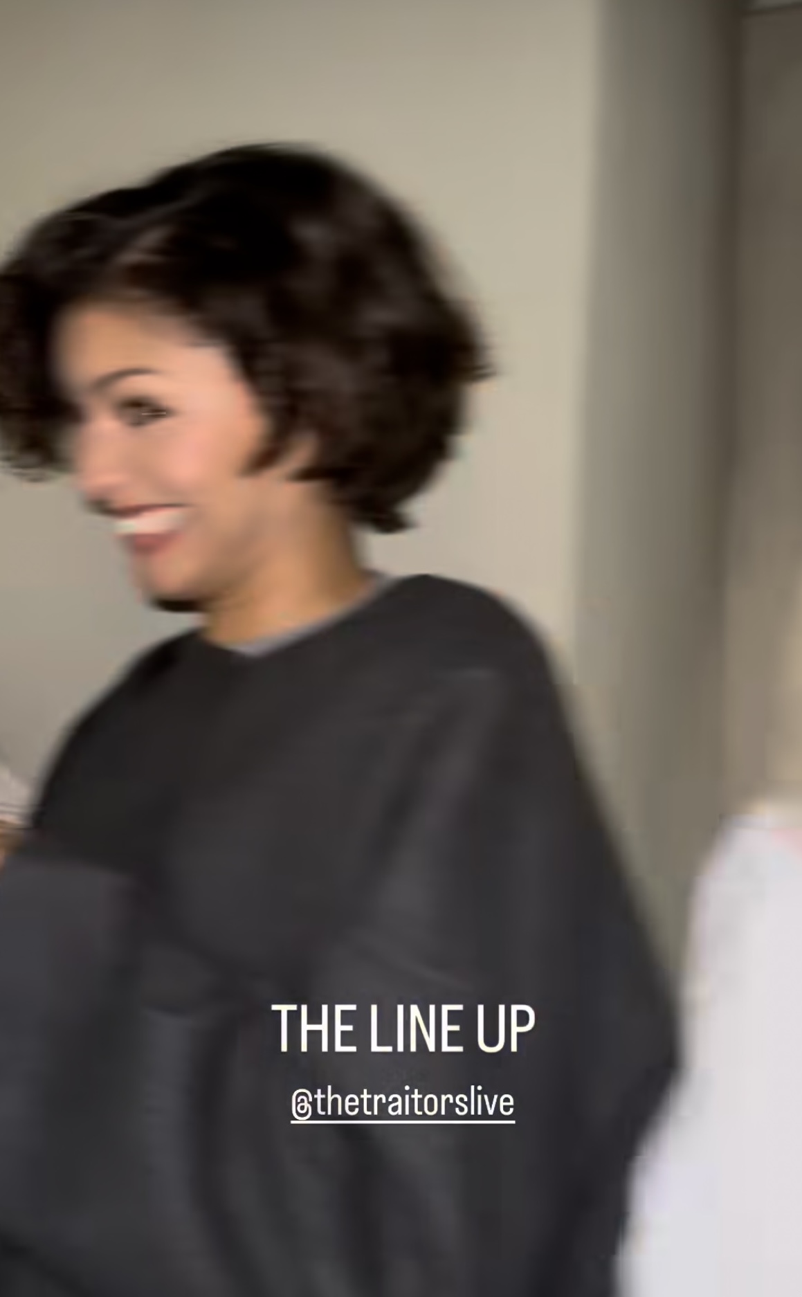 a screenshot of a woman with short dark hair