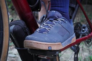 Image shows Anna wearing the Crankbrothers Stamp lace flat shoes while on a gravel bikepacking trip.