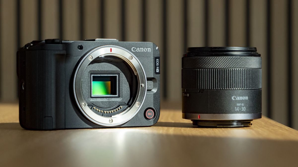 Canon EOS R50 V on a wooden table alongside the 14-30mm PZ lens