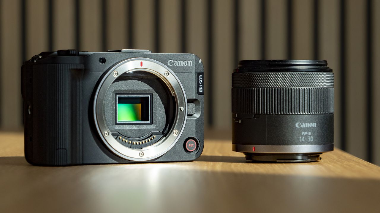 Canon EOS R50 V on a wooden table alongside the 14-30mm PZ lens