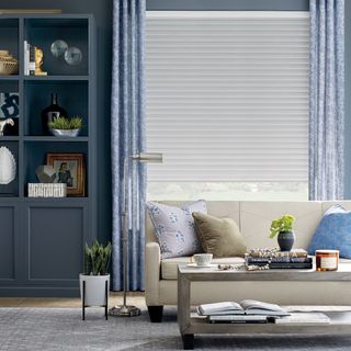 living room with sofa and cushions and open grey shelf