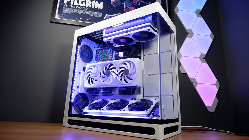 A finished white gaming PC on a table with Nanoleaf lighting panels behind it and RGB enabled.