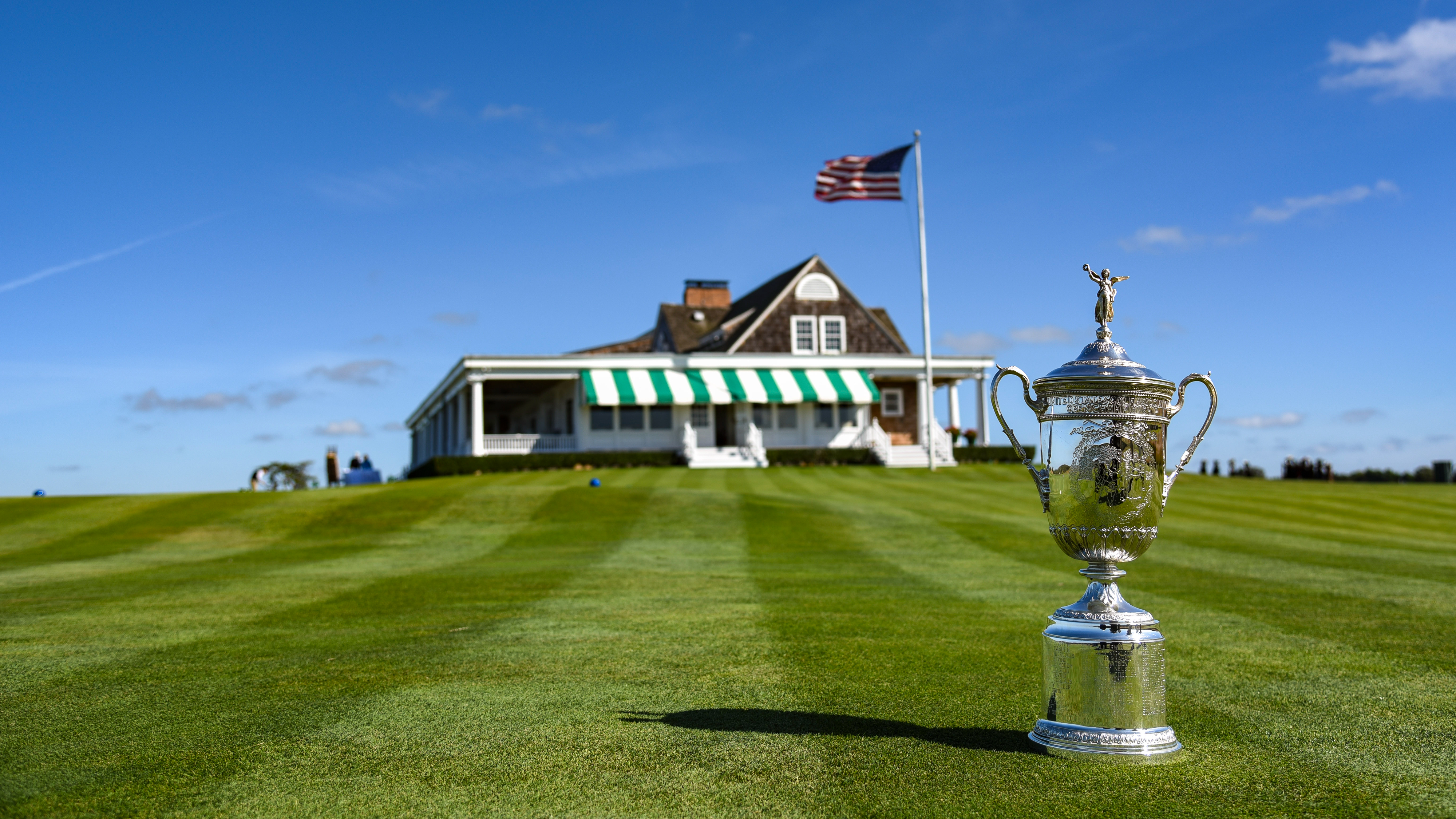 US Open trophy positioned on grass outside of Shinnecock Hill&#039;s clubhouse