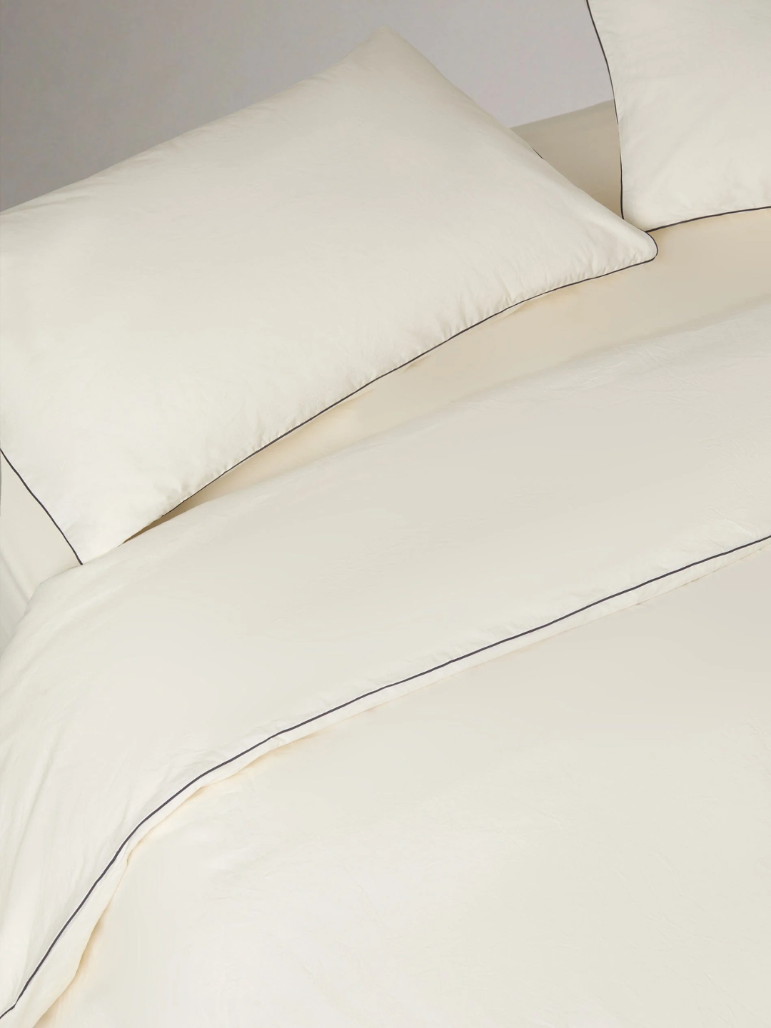 A buttermilk cotton bedding with black piping from Rise &amp;amp; Fall