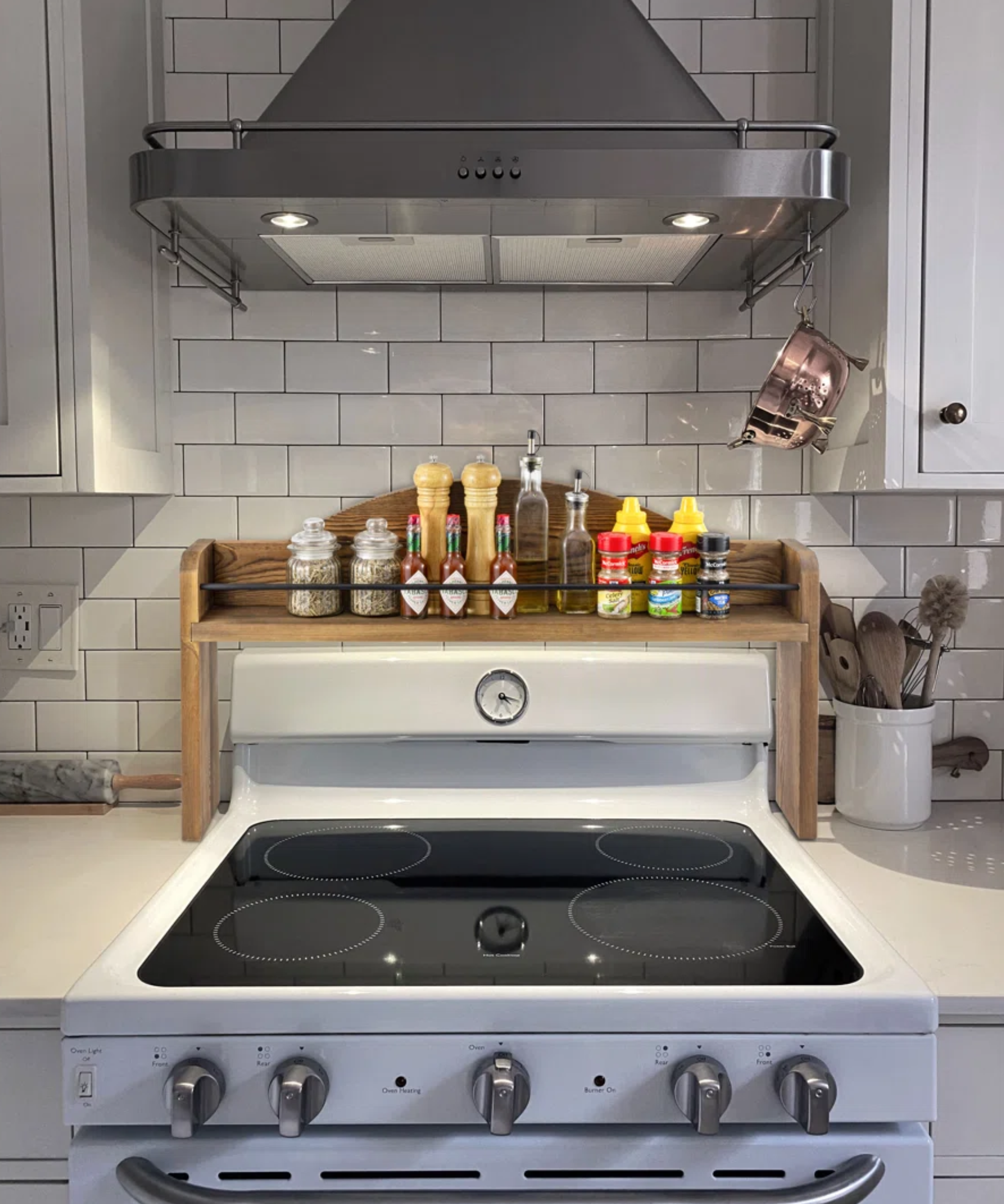 an oven with a wooden shelving unit behind it