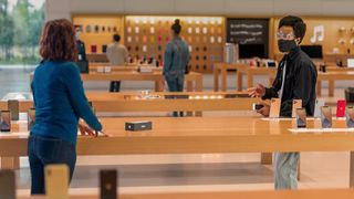 Two people in an Apple Store discussing a trade in