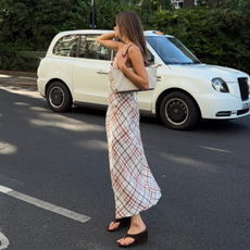 Influencer Sara Walker wearing a check slip dress, wedge heel sandals and shoulder bag. 