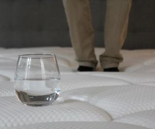 A glass of water on the DreamCloud Luxury Hybrid Mattress.