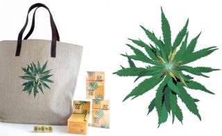 Grey tote bag with black handles and intricately embroidered cannabis design, photograped next to yellow packs against a white background