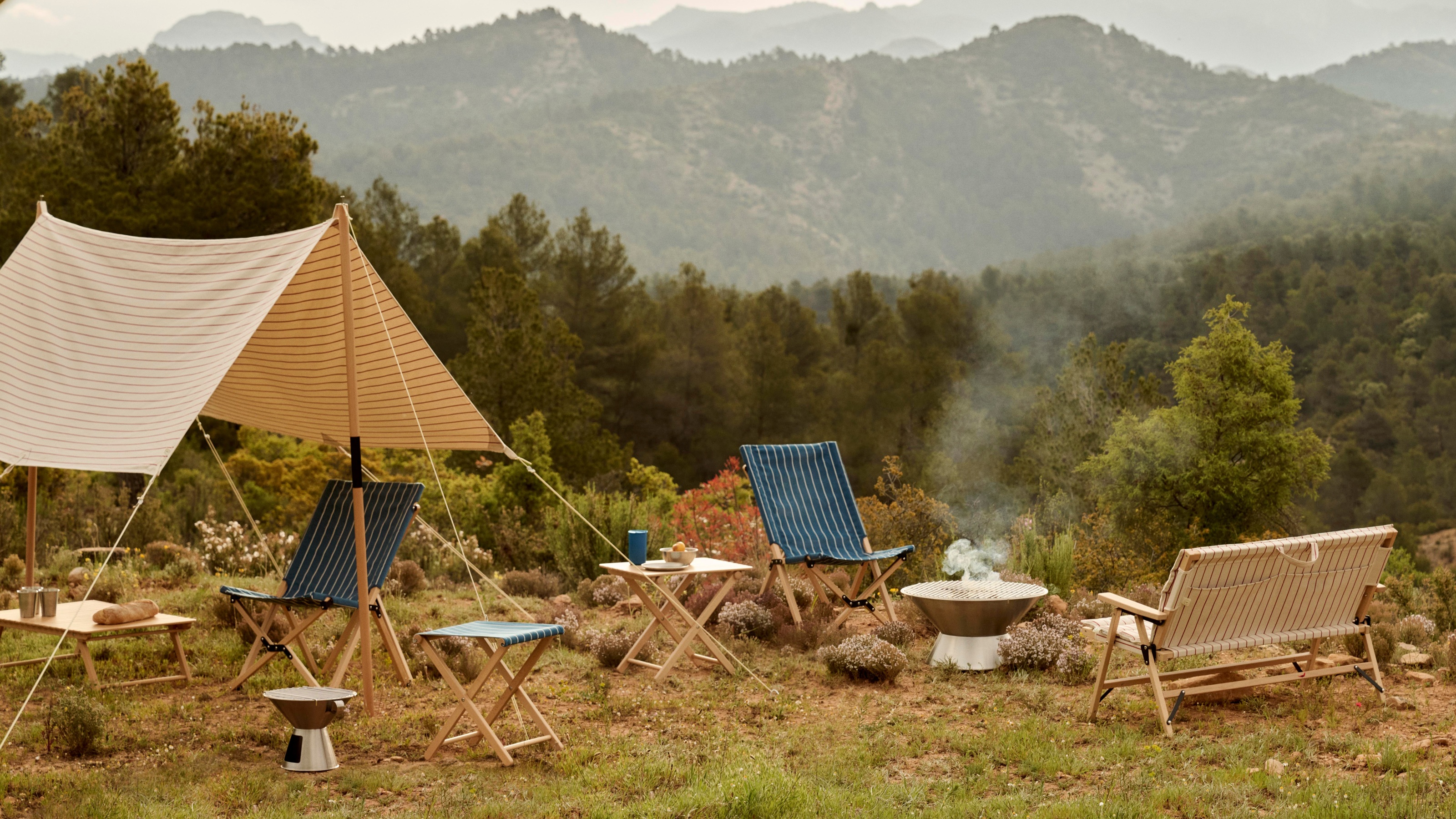 an outdoor camping set up in the mountains with outdoor furniture