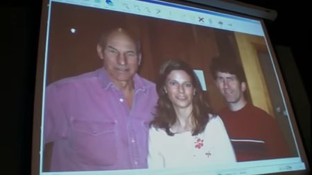 A computer screen shows a photo featuring Todd Howard, his wife, and Patrick Stewart