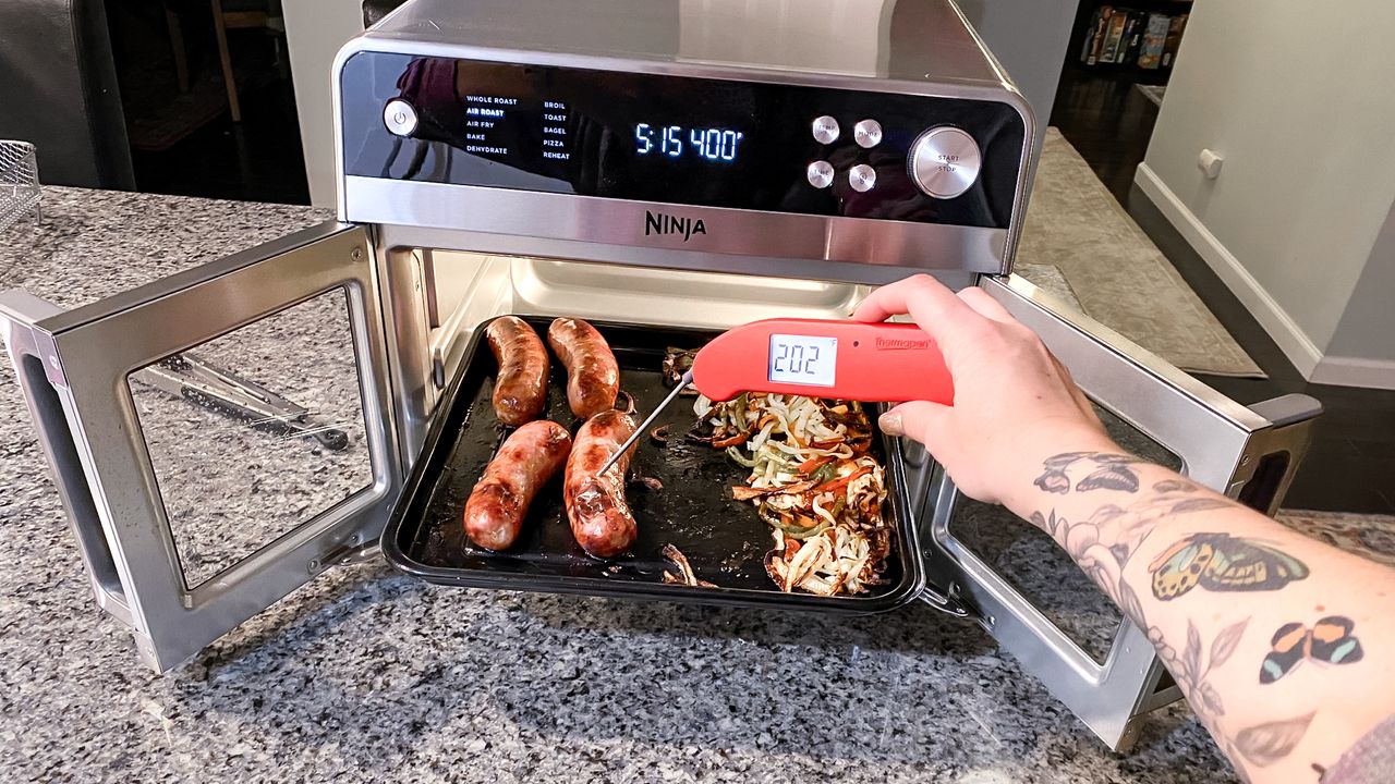 Ninja French Door Premier Air Fryer on a kitchen counter with doors open showing meat cooking