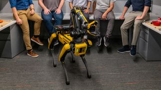 From left to right: team members Lukas Schmid, Nathan Hughes, Dominic Maggio, Yun Chang, and Luca Carlone. In front stands the robotic dog.