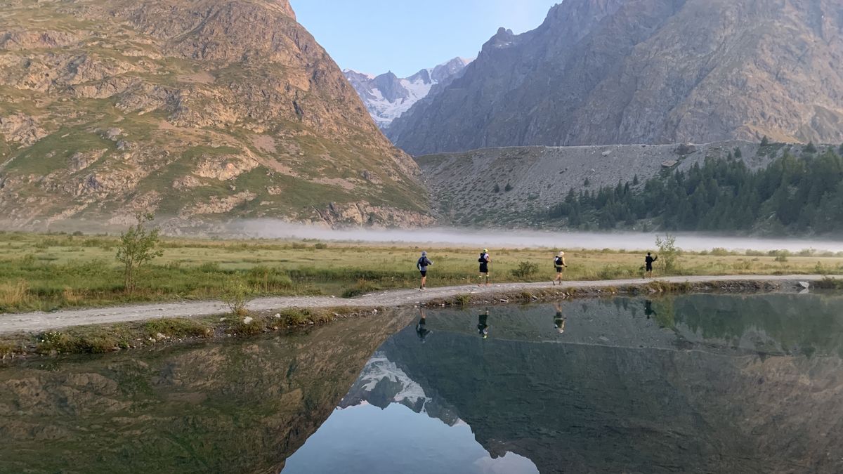 Runners in the UTMB reflected in Lac Combal