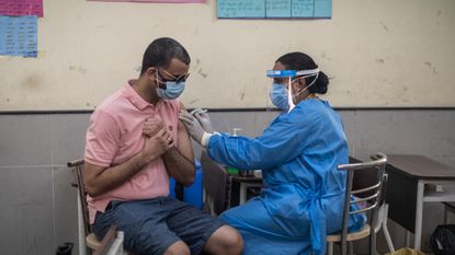A man receives his Covid-19 vaccine in New Delhi, India