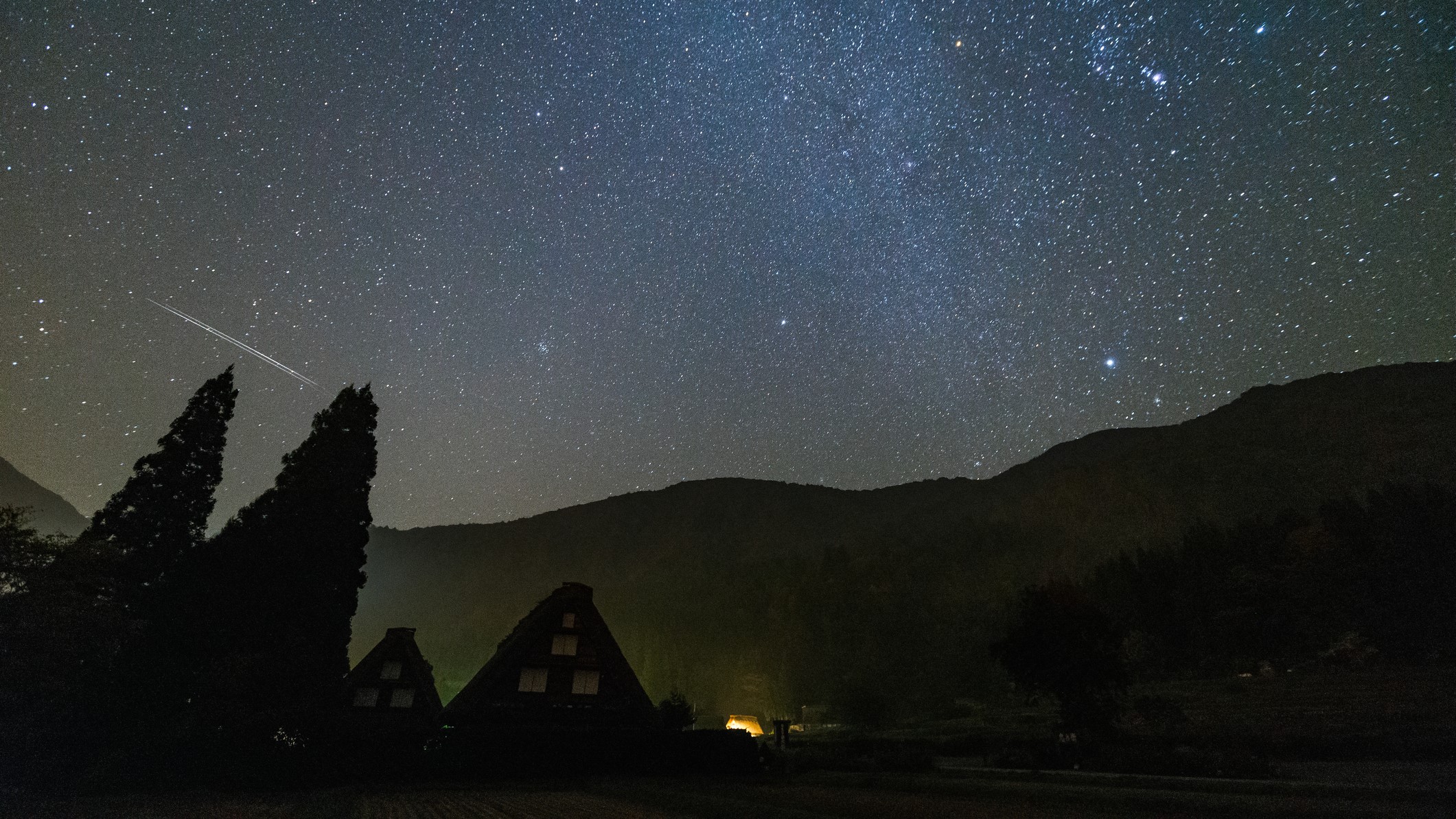 The Orionid meteor shower is a result of Halley's Comet. This photograph shows an Orionid meteor shower above Shirakawa-go, Japan.