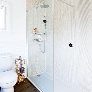 shower with heagon mosaic tiles and white commode and wooden floor