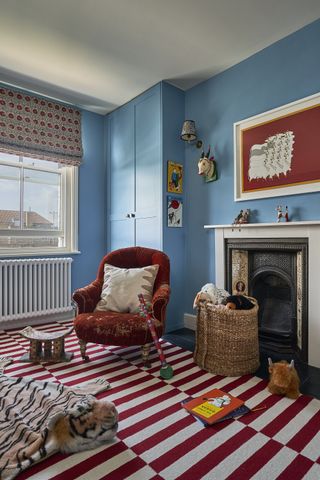 A blue color on the walls is paired with red on the floor and chair