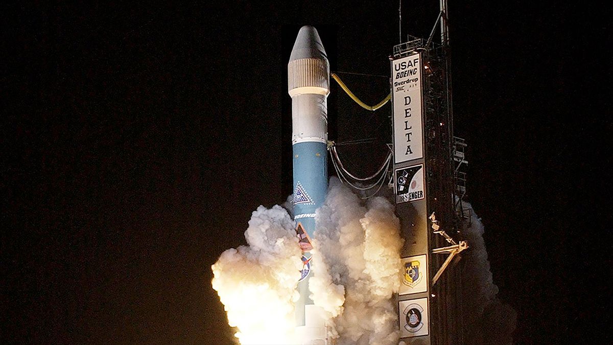 a blue and white rocket lifts off into the night sky