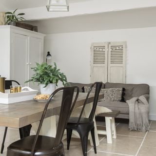 dining area with white wall and potted plant on wooden table