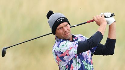 Marcel Siem wearing a beanie hat hitting a fairway wood shot