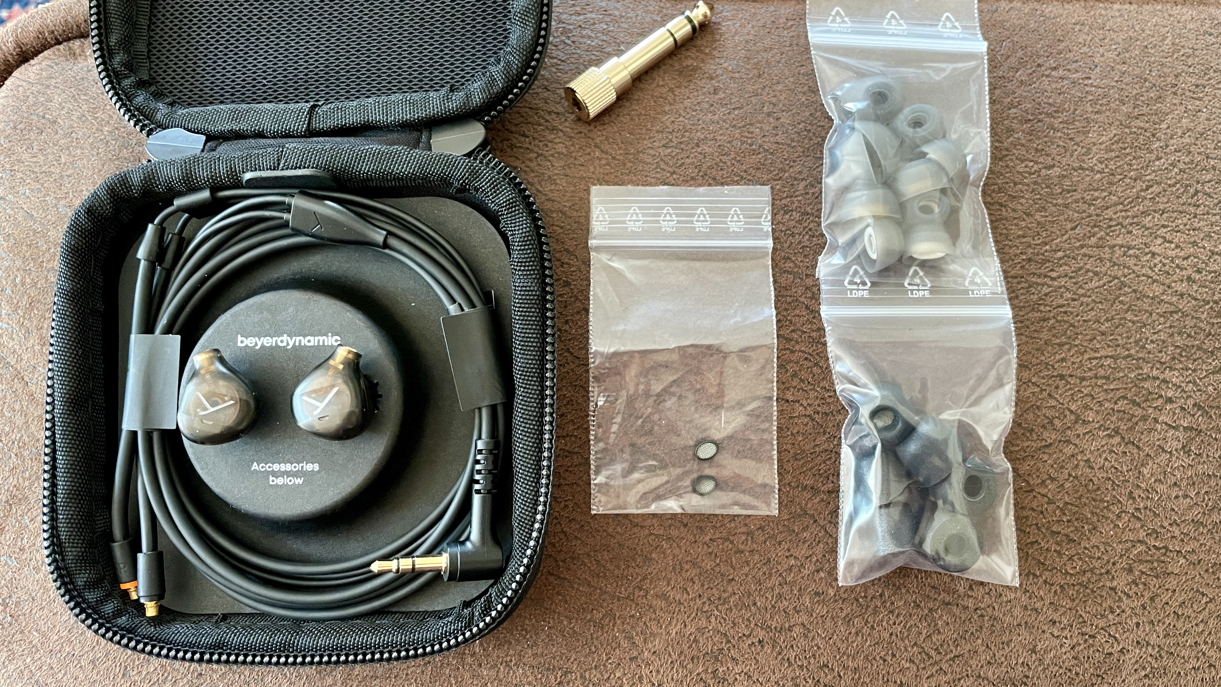 Beyerdynamic&#039;s DT 72 IE earbuds for vocals and guitar on brown background, showcasing the accessories