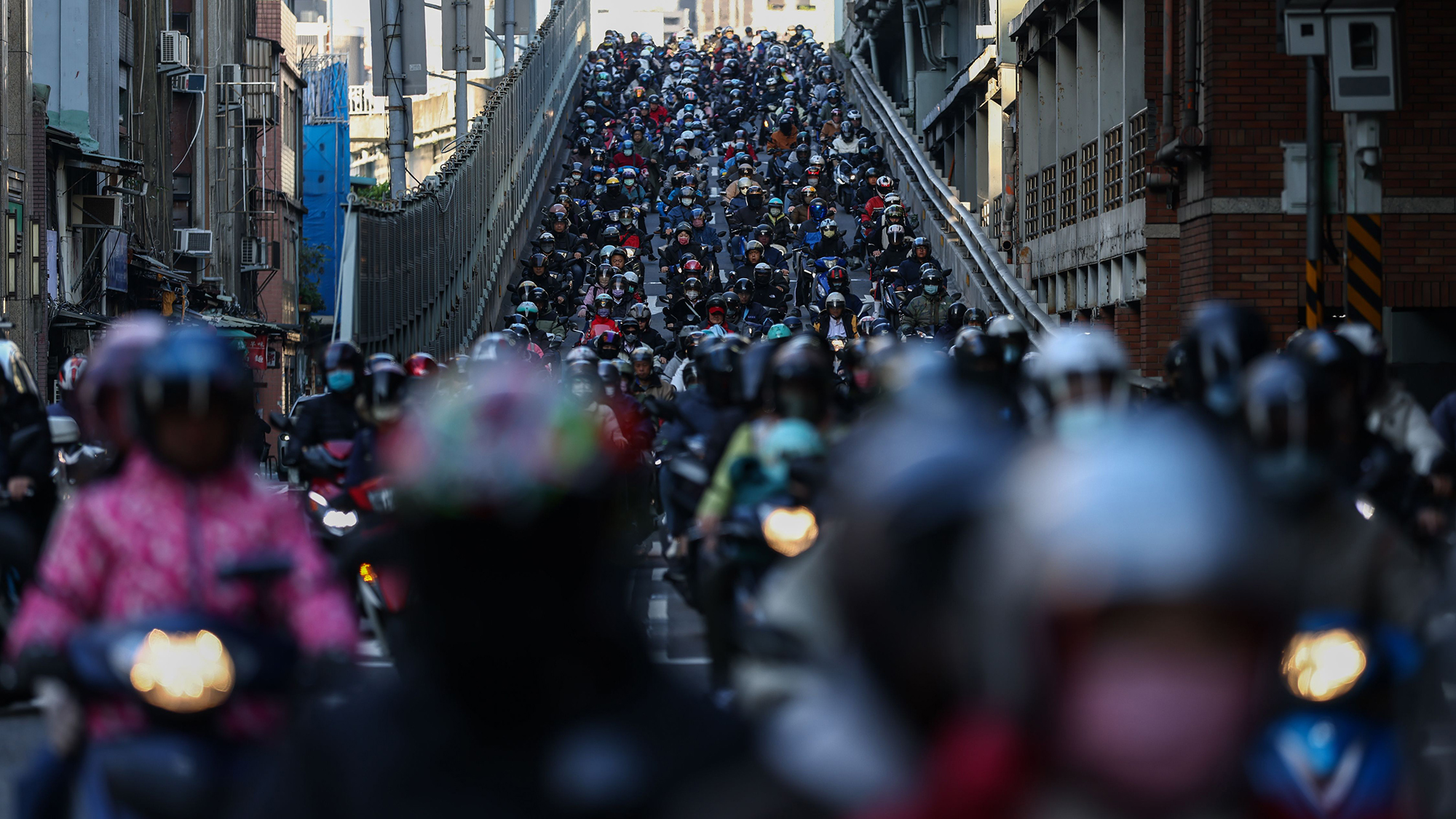 Hundreds of motorists on scooters crowd the road during morning rush hour in Taipei, Taiwan