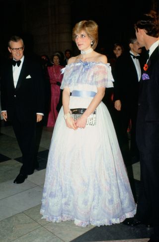 Princess Diana wearing a blue gown with an off the shoulder neckline and floral detailing on the skirt