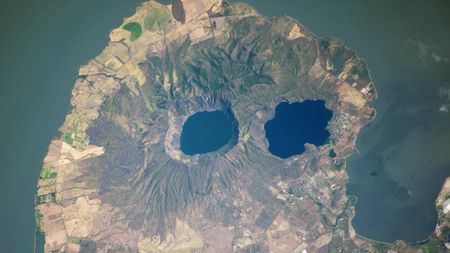A satellite photo of a rounded peninsula in a lake, with two eye-like lakes at its center