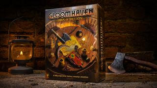 Gloomhaven: Jaws of the Lion box beside a lamp and hatchet